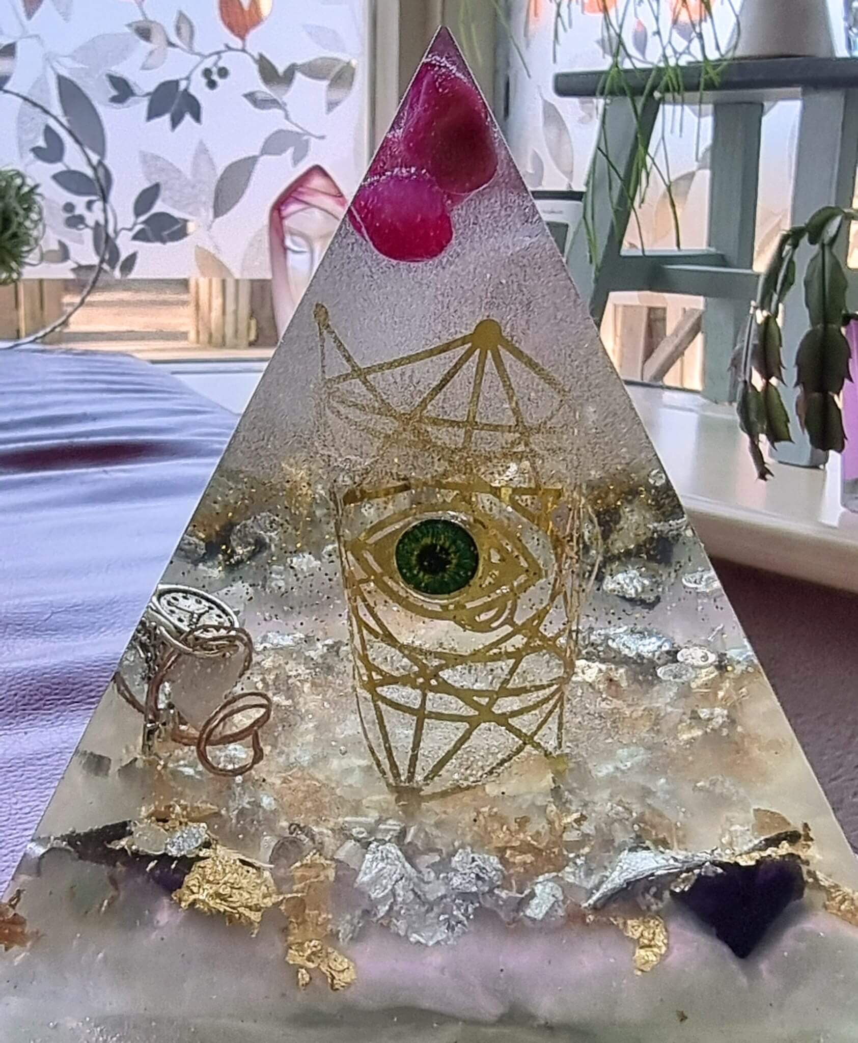 Transparante orgoniet piramide met alziend oog en geometrische lijnen
