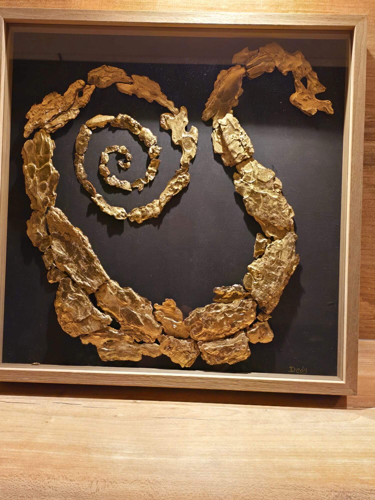 Gouden spiraal-sculptuur in houten lijst